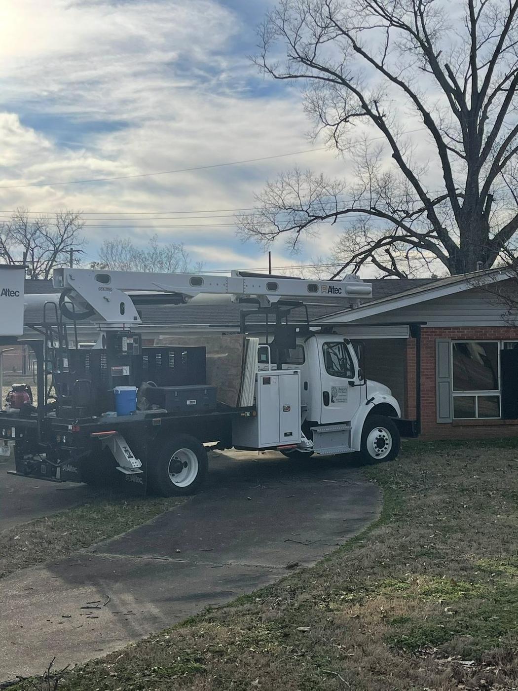 Bucket truck in a residential driveway — Aaron&rsquo;s Tree Service, Mid-South